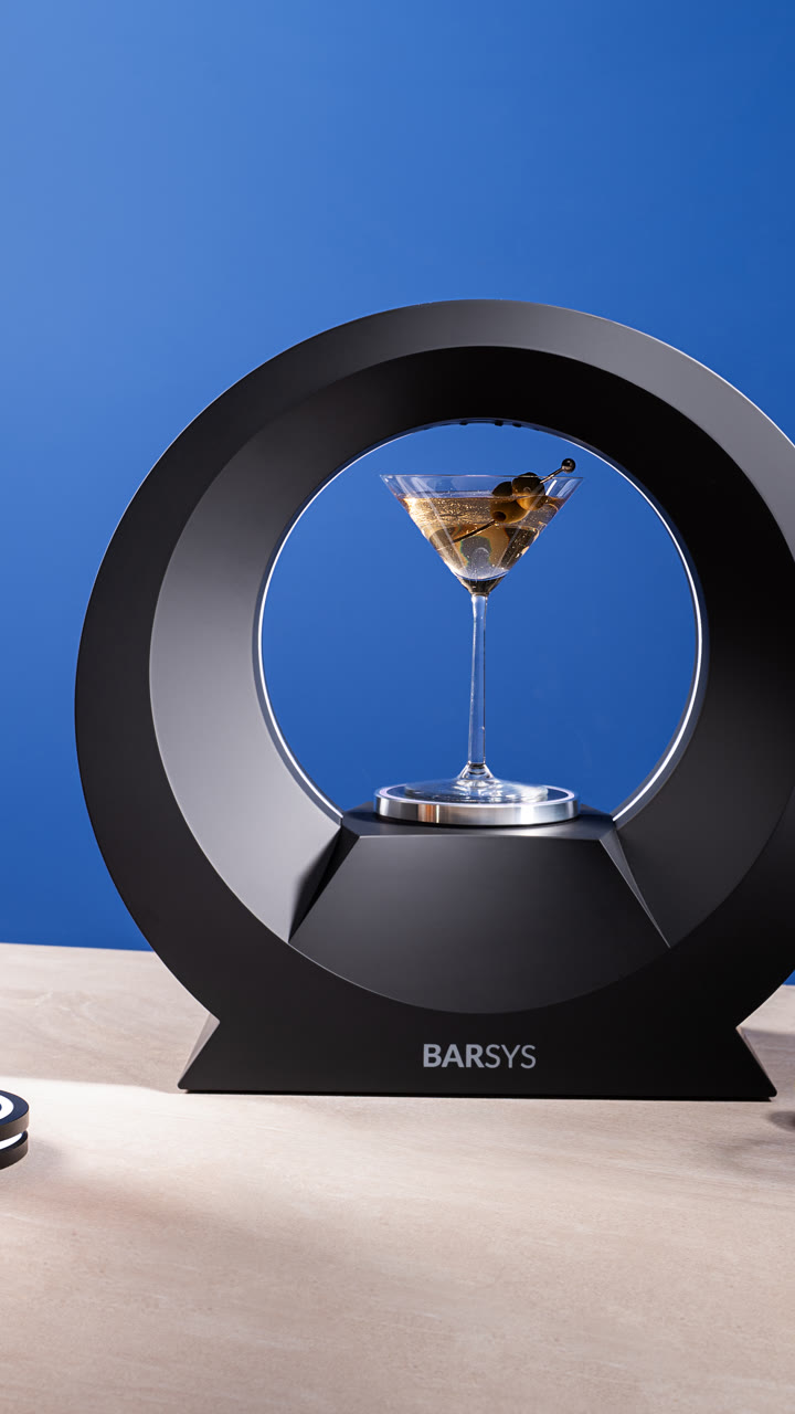 A Barsys 360 with a martini centered under the ring, against a blue backdrop.