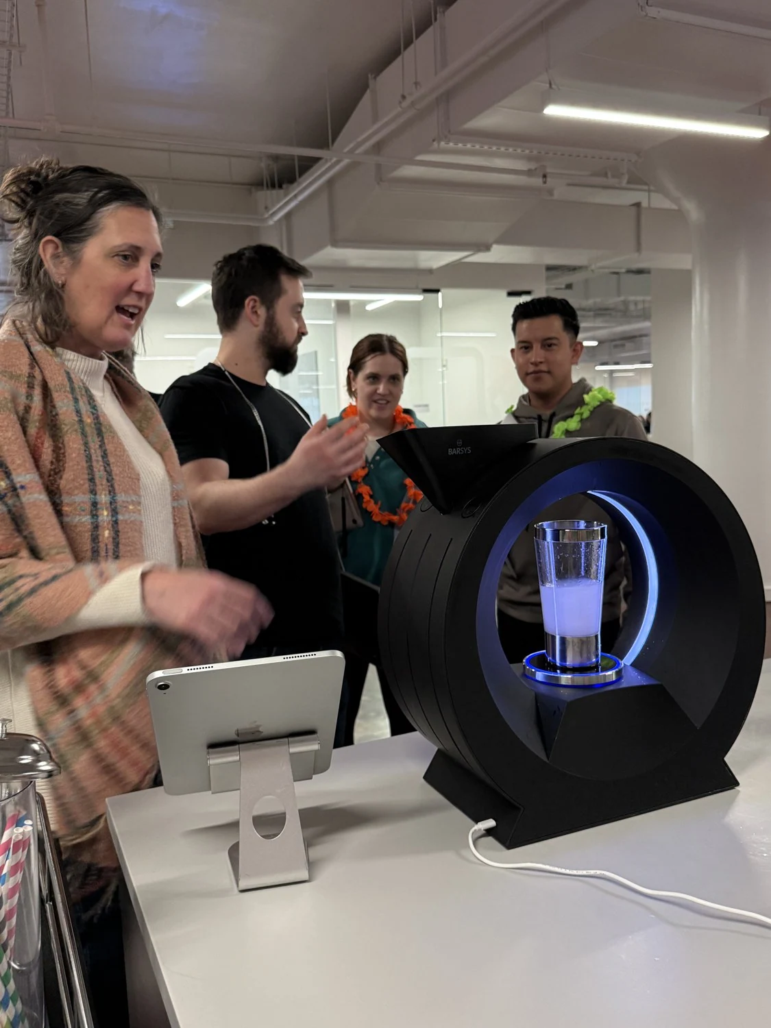 Guests reacting around an illuminated Barsys machine at the BuzzFeed office happy hour.