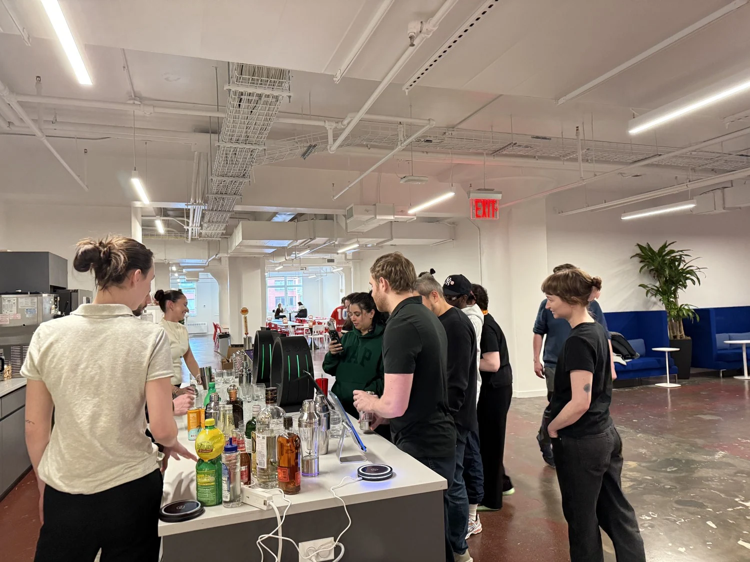 A wider view of the BuzzFeed workplace with guests gathered around the cocktail bar.